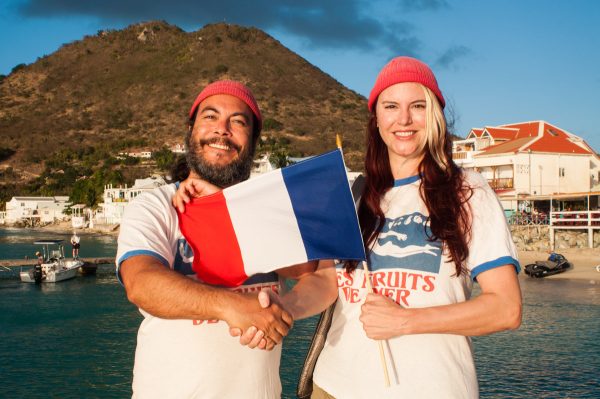 Les co-fondateurs de l'association Les Fruits de Mer affichent fièrement un drapeau avec leur nouveau logo, à Grand Case.